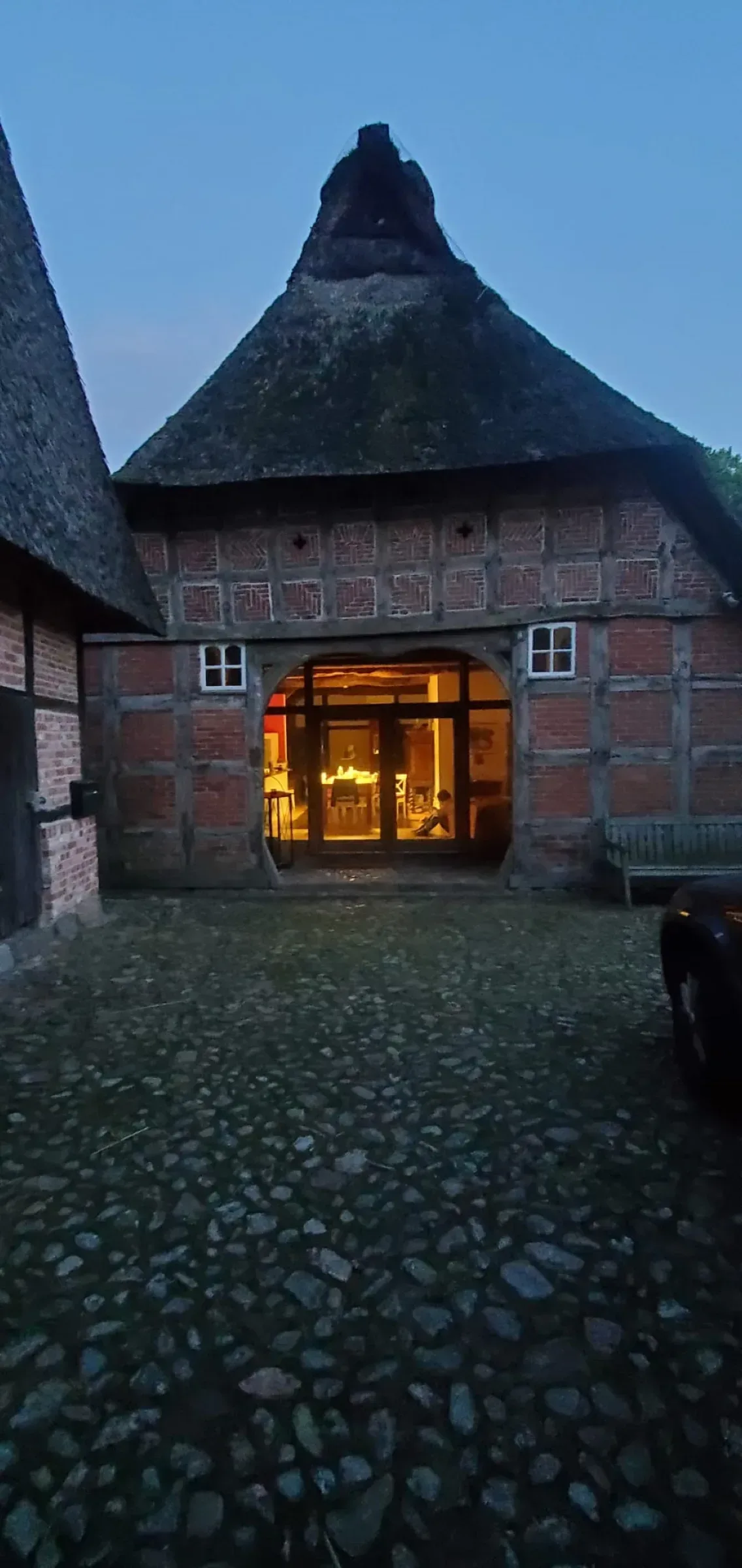 Historisches Fachwerkgebäude mit warm beleuchtetem Innenraum am Abend