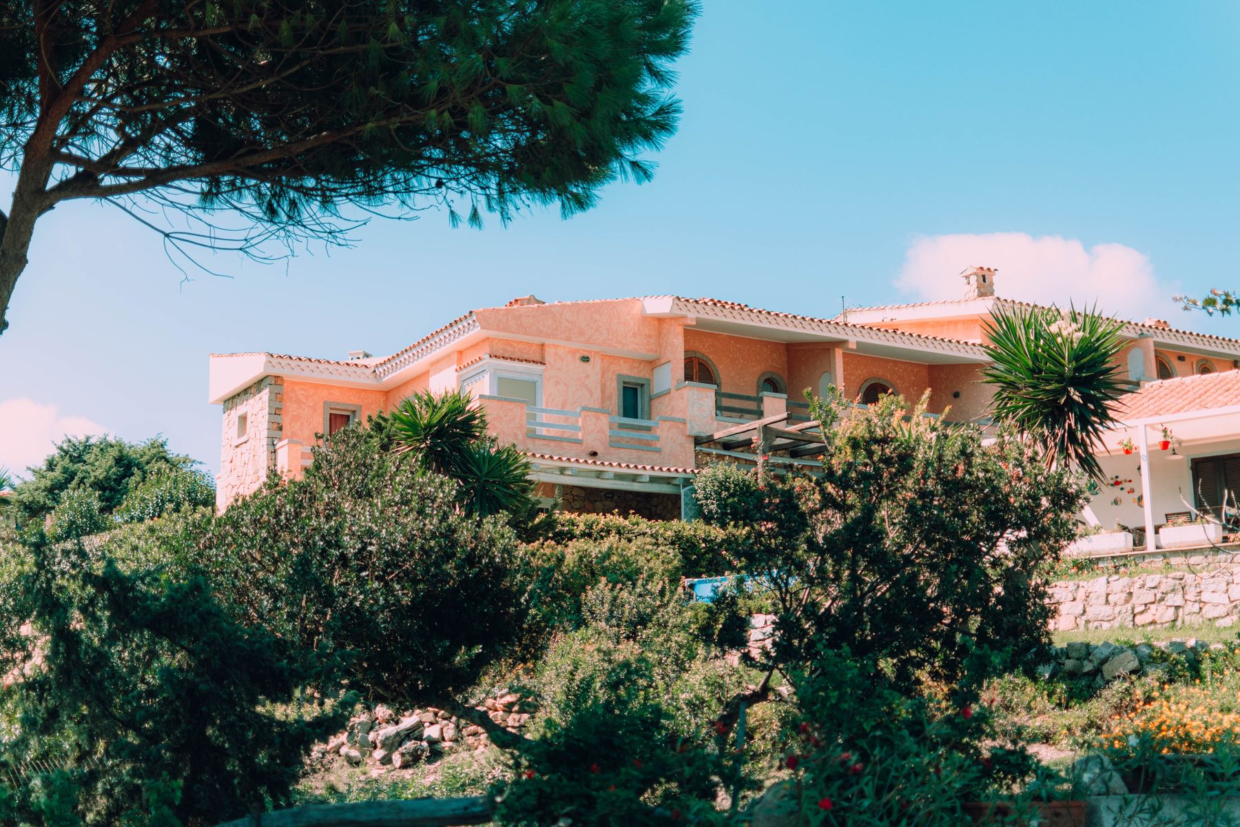 Sonnige mediterrane Villa unter blauem Himmel in einem üppig grünen Garten